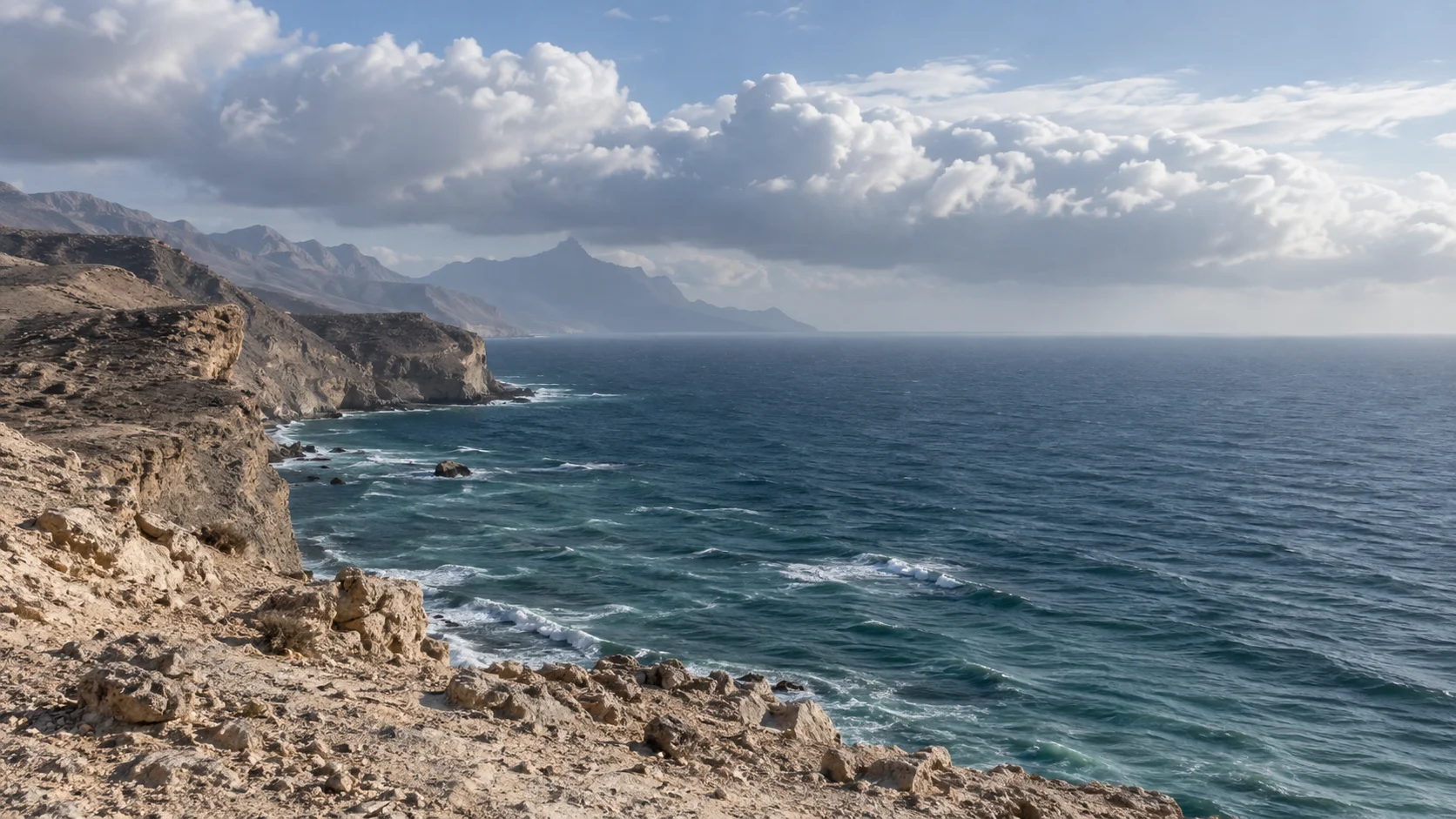 تصور بصري لساحل صخري جاف ومياه مفتوحة تحت سحب منخفضة